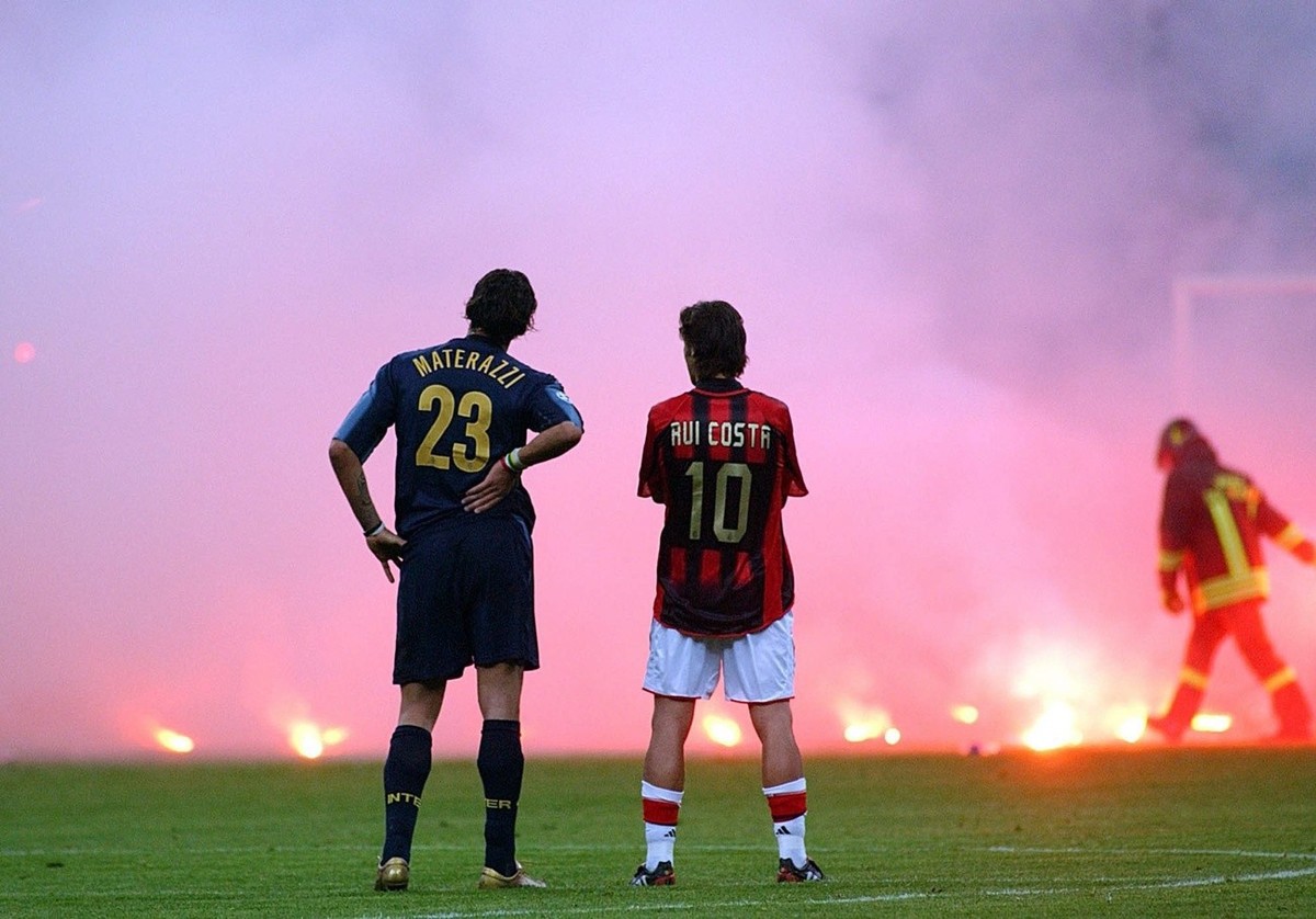 Inter Milan's Marco Materazzi, left, and AC Milan's Rui Costa look on as the match was stopped to clean up flares thrown by fans during their Champions League quarterfinal second leg match a ...