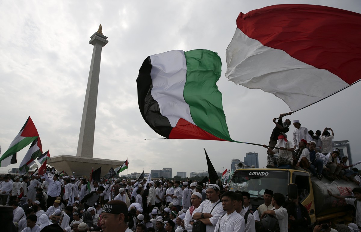 epaselect epa06394629 Indonesian Muslim activists wave Palestine and Indonesian flags during a protest against US President Donald J.Trump's decision to recognize Jerusalem as capital of Israel a ...