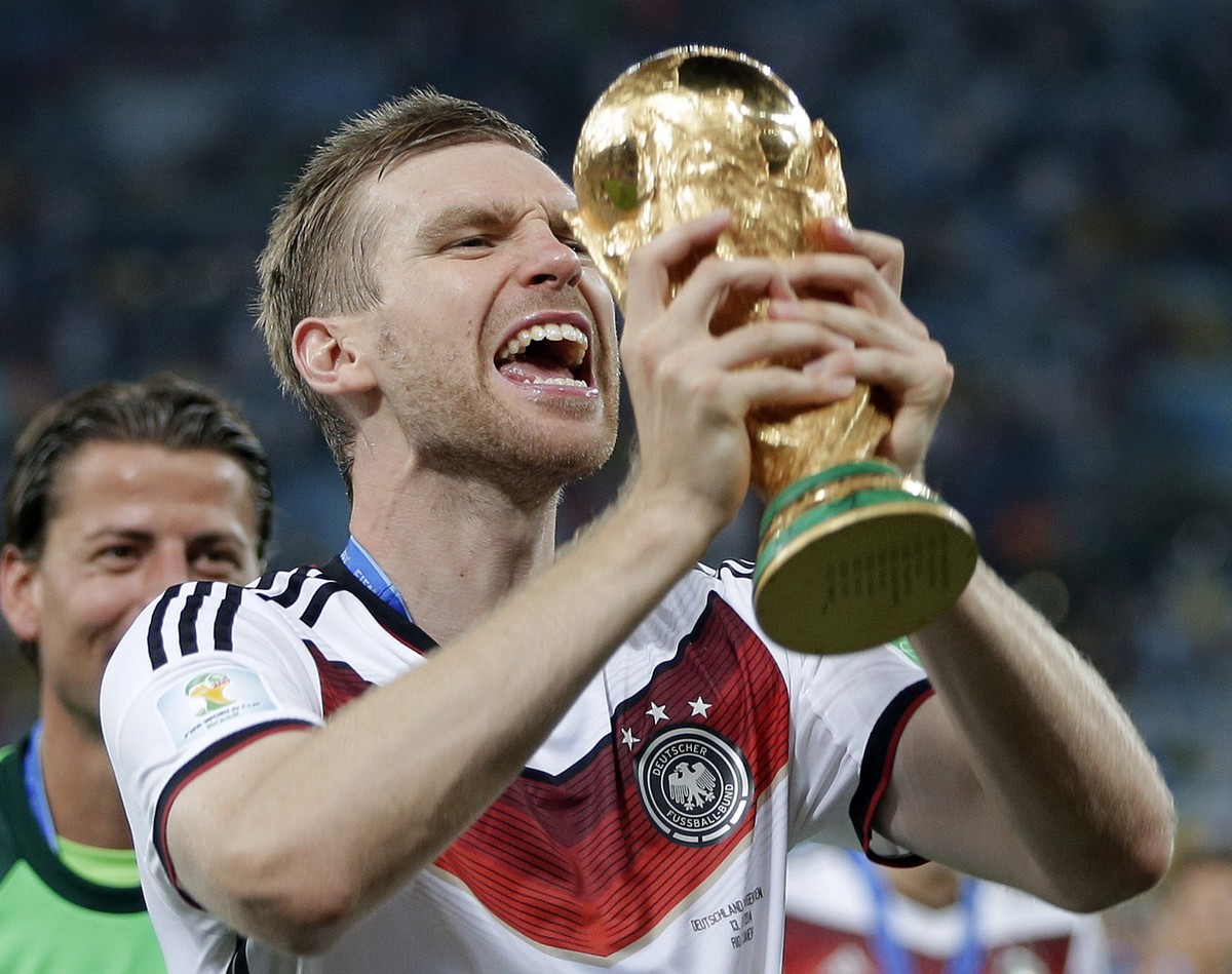 Germany's Per Mertesacker celebrates with the trophy after the World Cup final soccer match between Germany and Argentina at the Maracana Stadium in Rio de Janeiro, Brazil, Sunday, July 13, 2014. ...