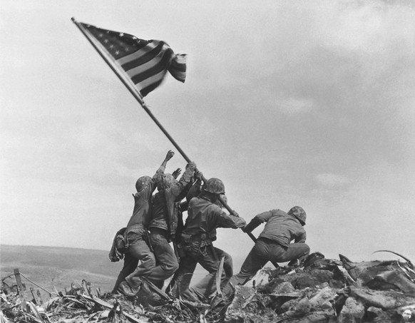 U.S. Marines of the 28th Regiment, 5th Division, raise the American flag atop Mt. Suribachi, Iwo Jima, on Feb. 23, 1945. Strategically located only 660 miles from Tokyo, the Pacific island became the  ...