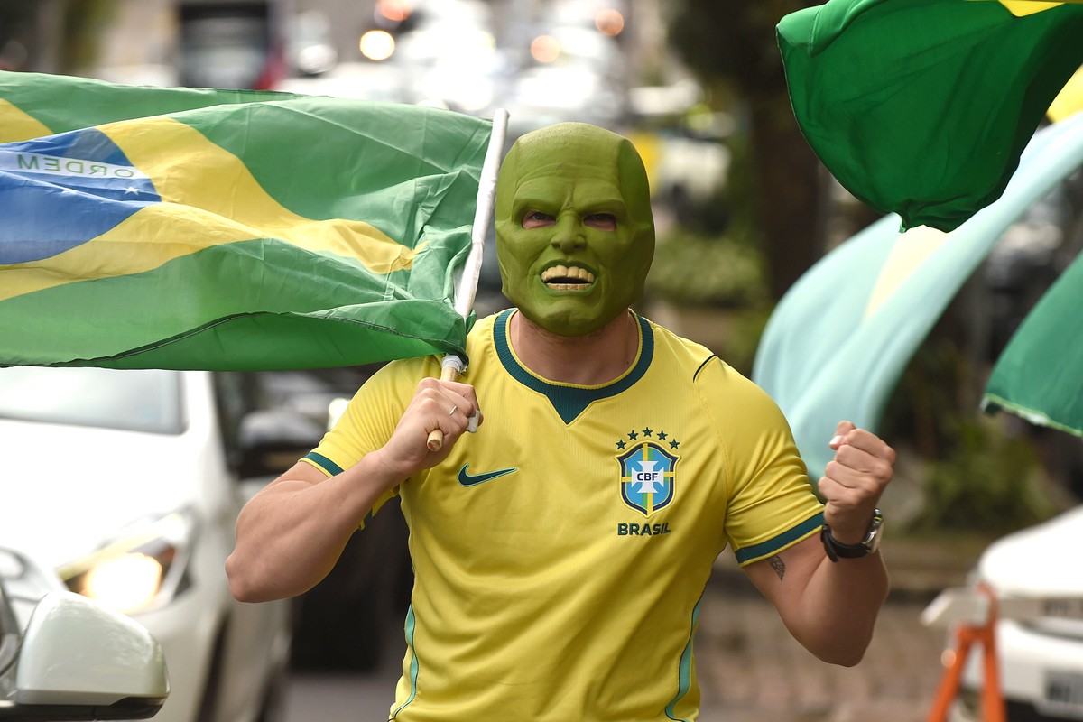 epa13331649 A supporter of Brazilian presidential candidate Flavio Bolsonaro holds a Brazilian flag in Porto Alegre, Brazil, 25 October 2026. Brazil holds the second round of its presidential election ...