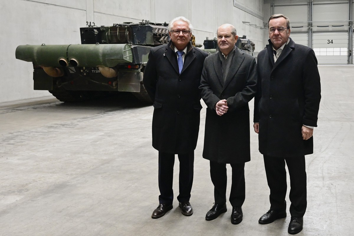 epa11147825 German Chancellor Olaf Scholz (C), German Defence Minister Boris Pistorius (R) and CEO of Rheinmetall Armin Papperger pose by Leopard 2 tanks as they visit a production line at the future  ...