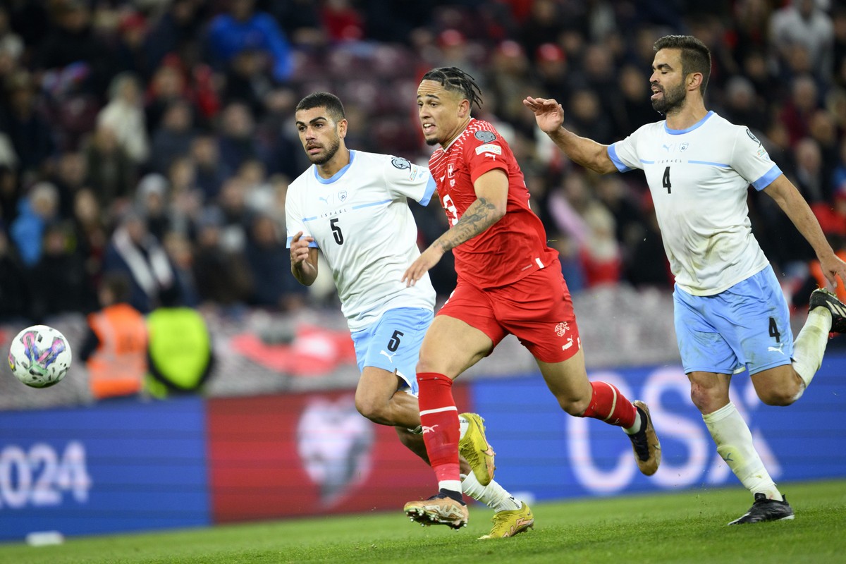 epa10548030 Switzerland's forward Noah Okafor (C) fights for the ball with Israel's defender Miguel Vitor (R) and Raz Shlomo (L) during the UEFA EURO 2024 qualifying group I soccer match bet ...