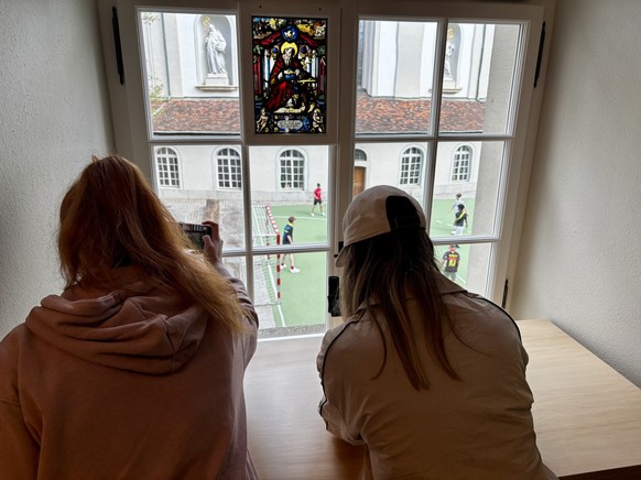 Freude am Fussball: Gianna und Katharina beobachten die Jungs, die im Innenhof des Klosters Fussball spielen.