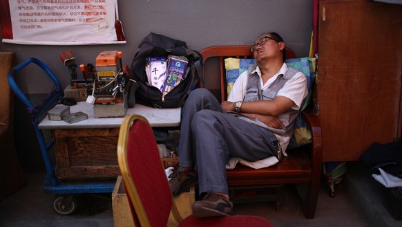 epa06784105 A Chinese man takes a nap outdoors during hot weather in Beijing, China, 04 June 2018. Parts of Beijing were forecast to hit 35 degrees Celsius on 04 June, with higher temperatures excepte ...