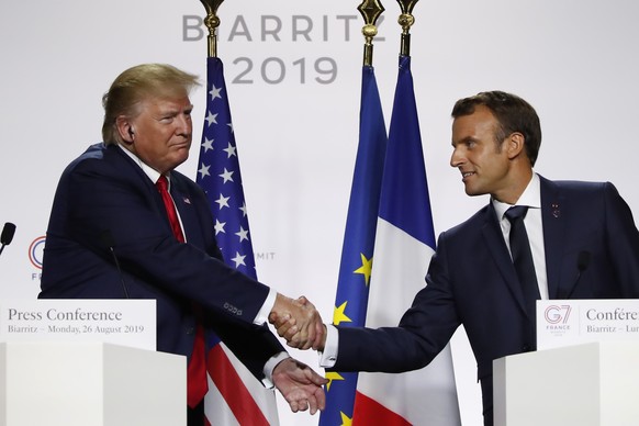 French President Emmanuel Macron, right, and U.S President Donald Trump shake hands during the final press conference during the G7 summit Monday, Aug. 26, 2019 in Biarritz, southwestern France. Frenc ...