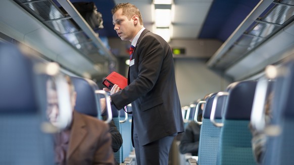 ARCHIVBILD ZUR VERGABE DER FERNVERKEHRSKONZESSIONEN DURCH DAS BAV, AM MONTAG, 23. OKTOBER 2017 - A ticket collector checks the passengers&#039; tickets in an InterCity train of the Swiss Federal Railw ...