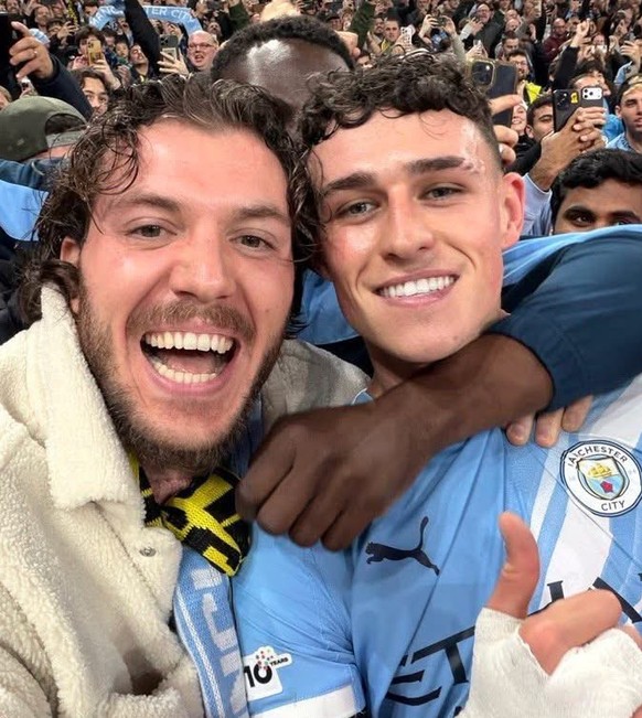 Phil Foden posiert beim Jubel mit einem Fan.