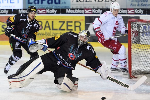 Le defenseur fribourgeois Sebastian Schilt, gauche, et le gardien Fribourgeois Benjamin Conz, centre, luttent pour le puck avec lÕattaquant lausannois Harri Pesonen, droite, lors du match du championn ...