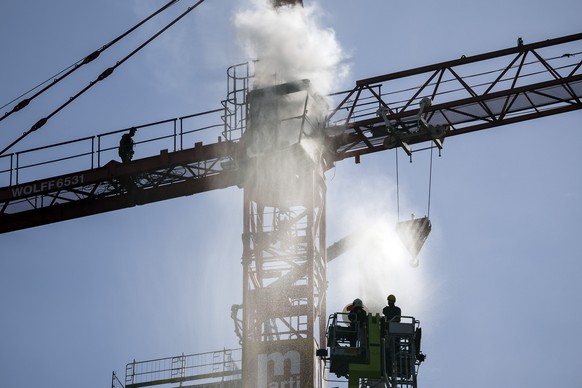 Ein Mann entfacht auf einem Baukran am Bahnhof Oerlikon ein Feuer, am Dienstag, 17. Mai 2022 in Zuerich. (KEYSTONE/Michael Buholzer)