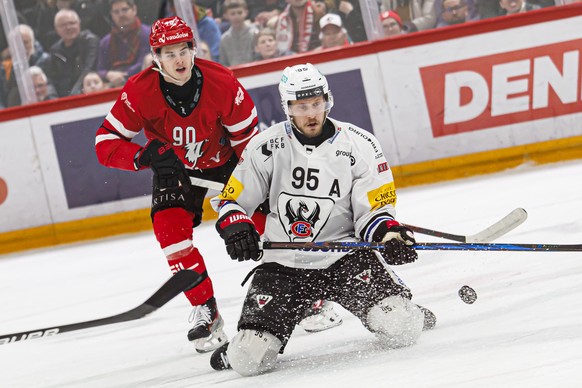 Theo Rochette (LHC), gauche, lutte pour le puck avec Jacob De la Rose (HCFG), droite, lors du match du championnat suisse de hockey sur glace de National League entre Lausanne HC, LHC, et le HC Fribou ...