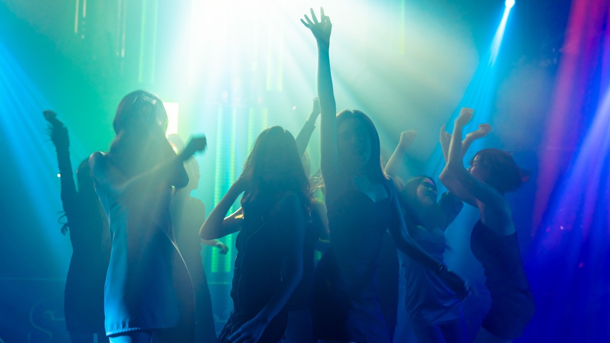 Silhouette Bild von Menschen tanzen in Disco Nachtclub zu Musik von DJ auf der Bühne . Neue Jahr Nacht Party und Nachtleben Konzept .