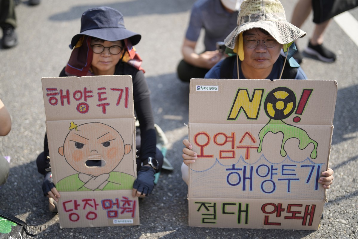 Protesters hold signs during of a rally to demand the stop of the Japan's release of treated radioactive water into the sea from the damaged Fukushima nuclear power plant and denounce the South K ...