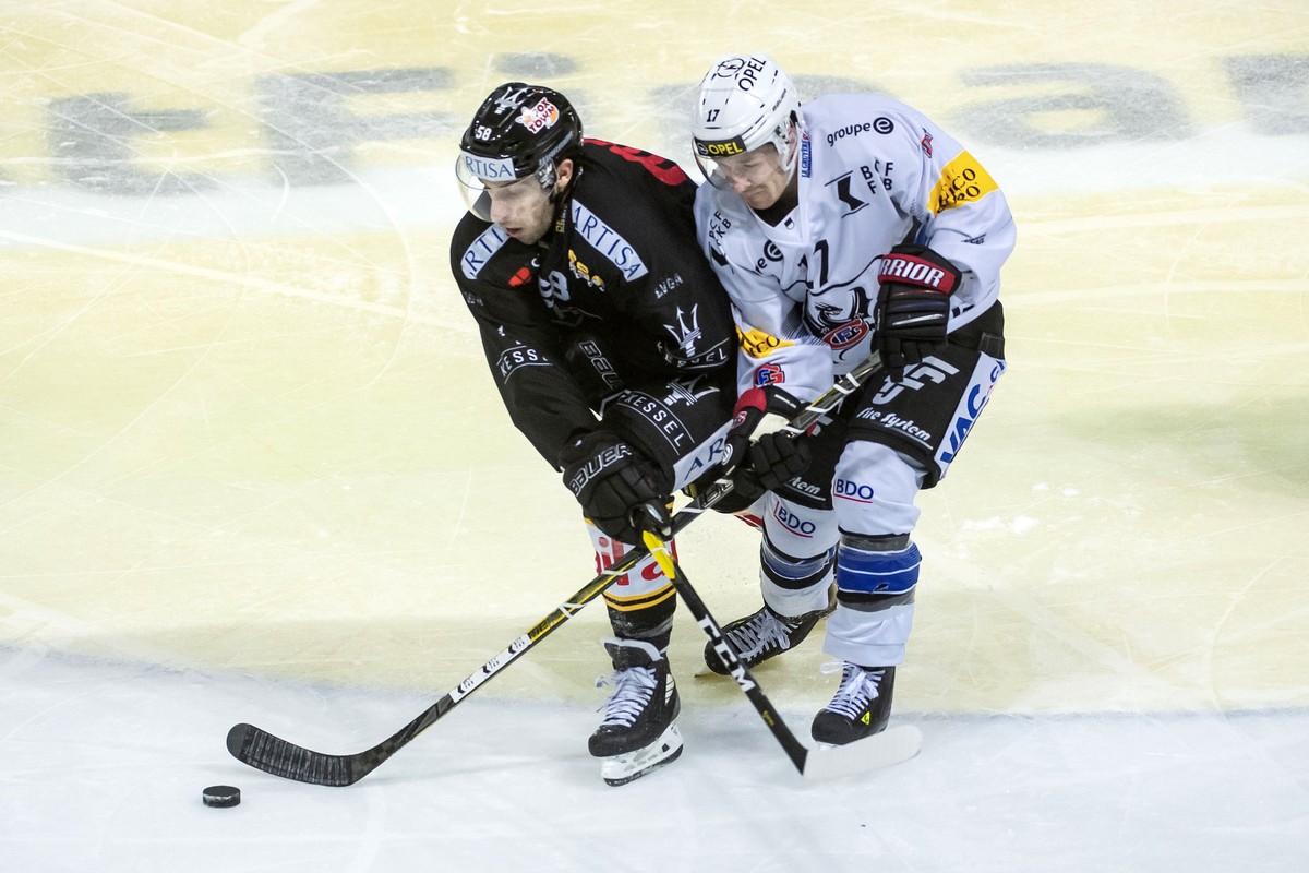 Lugano's player Romain Loeffel, left, and Gotteron's player Andrew Miller, right, during the preliminary round game of National League Swiss Championship between HC Lugano and HC Fribourg-Go ...