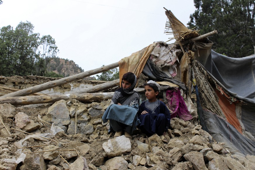 Afghan boys site near their damaged house that was destroyed in an earthquake in the Spera District of the southwestern part of Khost Province, Afghanistan, Wednesday, June 22, 2022. A powerful earthq ...