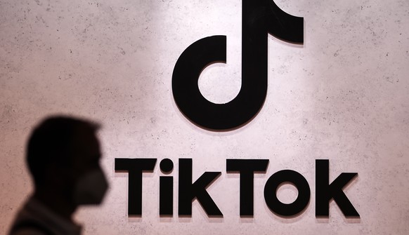 FILE - A visitor passes the TikTok exhibition stands at the Gamescom computer gaming fair in Cologne, Germany, Thursday, Aug. 25, 2022. A Russian court has fined TikTok for failing to delete LGBT mate ...