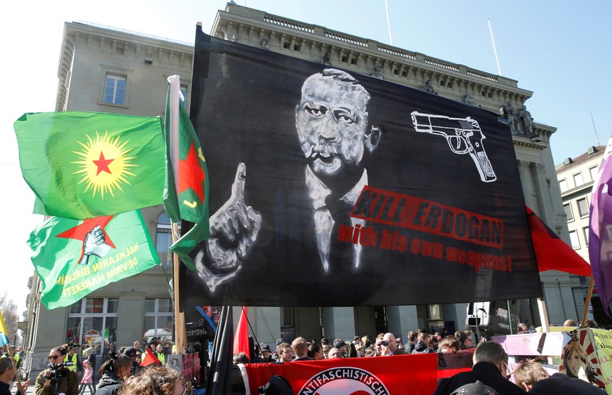 FILE PHOTO: People hold banners and flags during a demonstration against Erdogan dictatorship and in favour of democracy in Turkey, in Bern, Switzerland March 25, 2017. REUTERS/Ruben Sprich/File Photo