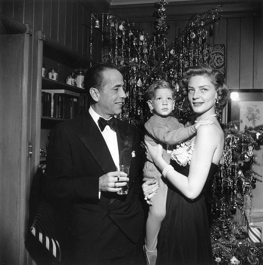 American actor Humphrey Bogart (1899 - 1957) with his wife Lauren Bacall and their son Stephen at their home in Beverly Hills in California on Christmas Eve., 1951 (Photo by Slim Aarons/Getty Images)