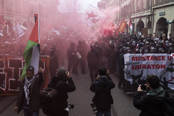 People hold banners and wave Palestinian flags during an unauthorized rally in solidarity with the Palestinian people in Bern, Switzerland, 11 October 2025. (KEYSTONE/Peter Klaunzer)