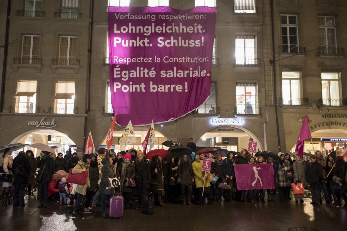 Teilnehmerinnen des Frauenkongresses zeigen Plakate mit den Aufschriften "Verfassung respektieren: Lohngleichheit Punkt. Schluss!" und "Respectez la constitution: Egalite salariale. Poi ...