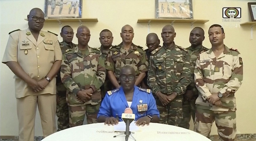 In this image taken from video provided by ORTN, Col. Maj. Amadou Abdramane, front center, makes a statement late Wednesday, July 26, 2023, in Niamey, Niger, as a delegation of military officers appea ...