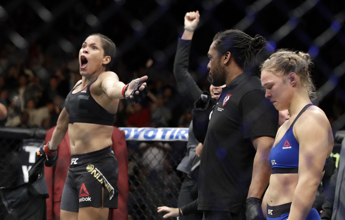 Amanda Nunes, left, celebrates her win as Ronda Rousey stands at right, after their women's bantamweight championship mixed martial arts bout was stopped in the first round at UFC 207, Friday, De ...