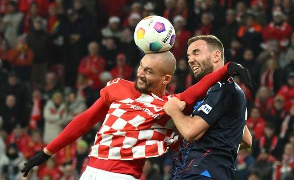 16.12.2023, Rheinland-Pfalz, Mainz: Fu�ball: Bundesliga, FSV Mainz 05 - 1. FC Heidenheim, 15. Spieltag, Mewa Arena. Der Mainzer Ludovic Ajorque (l) in Aktion gegen Heidenheims Benedikt Gimber. Foto: T ...