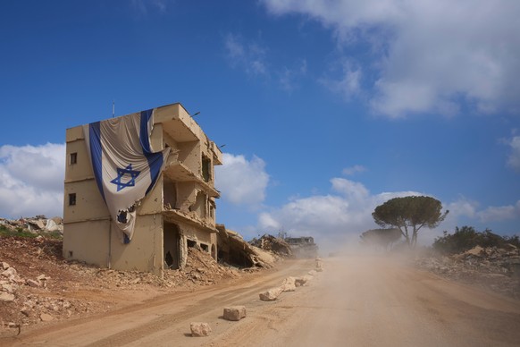 An Israeli flag hangs from a building in an area occupied by Israeli troops in southern Lebanon, Thursday, July 9, 2026. The Israeli military invited reporters on a tour of the strategic mountain topp ...