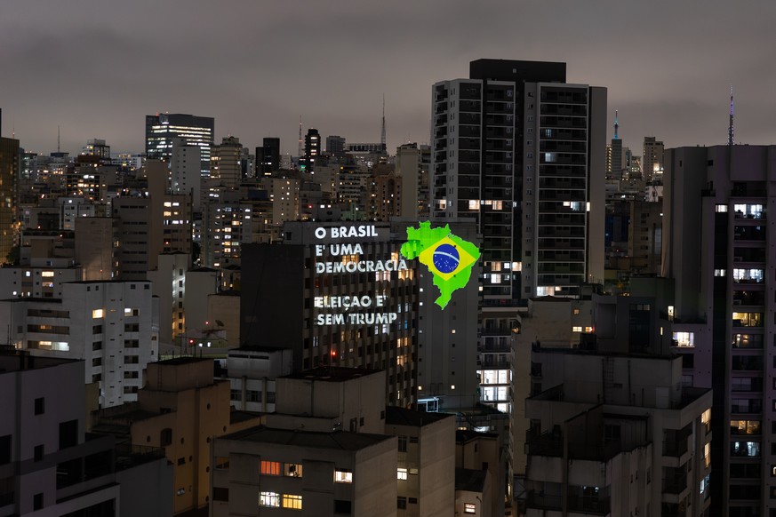 epa13277953 A photograph showing a projection on a building with the messages 'Brazil is a democracy' and 'Elections without Trump' in downtown Sao Paulo, Brazil, 02 October 2026.  ...