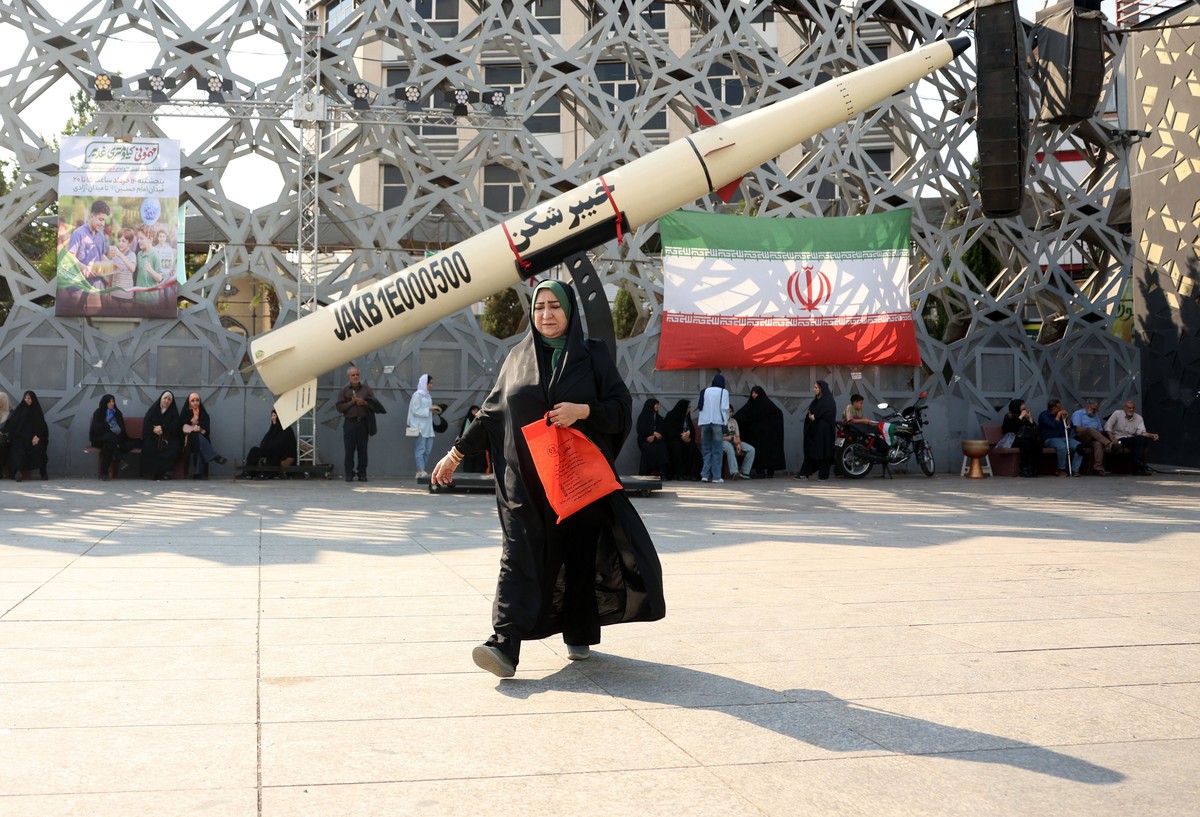 epa13015963 An Iranian woman walks past a mock Iranian Kheibarshekan ballistic missile during a rally to show their support and solidarity with Supreme Leader Ayatollah Mojtaba Khamenei, in Tehran, Ir ...
