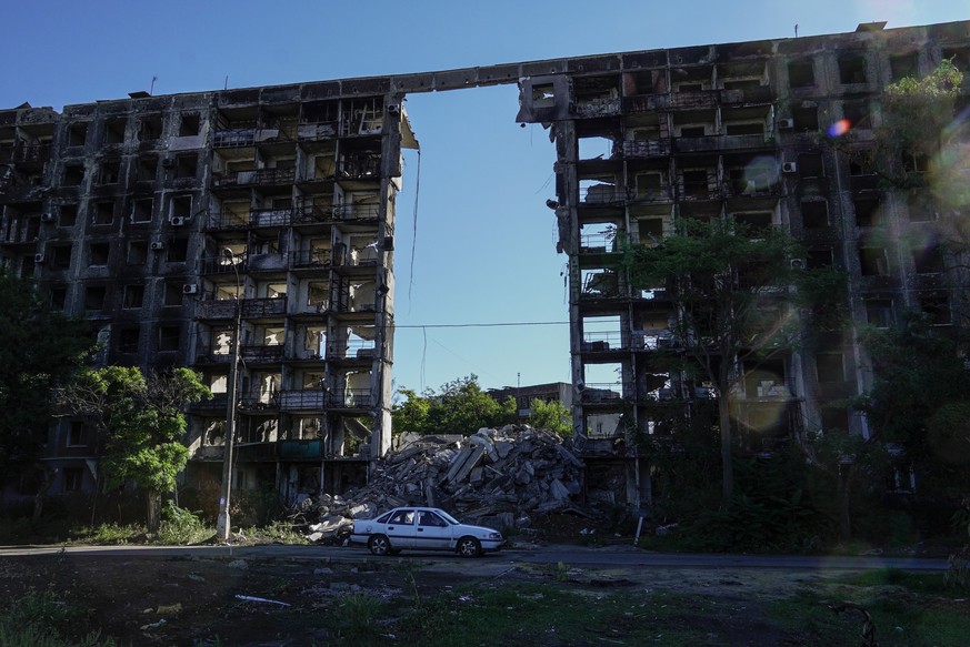 epa10206246 A car transits in front of a destroyed building in Mariupol, eastern Ukraine, 25 September 2022. From 23 to 27 September, residents of the self-proclaimed Luhansk and Donetsk People&#039;s ...