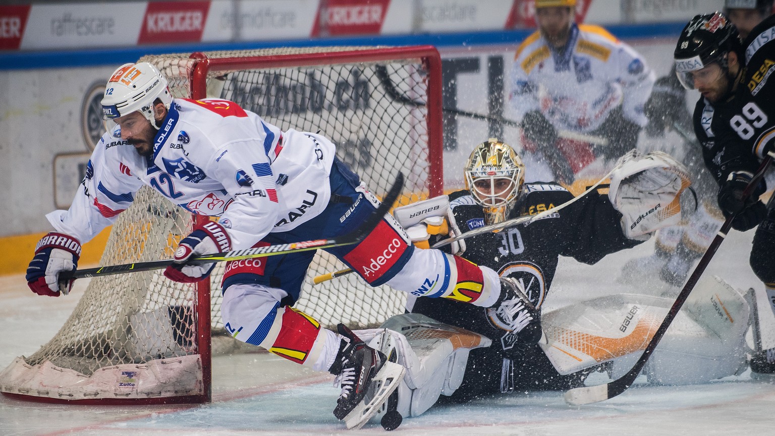 Lugano’s goalkeeper Elvis Merzlikins, right, fights for the puck with Zurich&#039;s player Pascale Pelletier, left, during the first match of the playoff final of the National League between HC Lugano ...