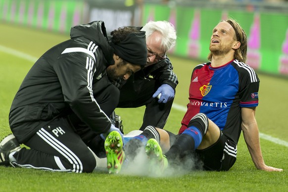 FC Basel's injured Michael Lang gets a medical treatment during the UEFA Europa League Round of 16 first leg soccer match between Switzerland's FC Basel 1893 and Spain's Sevilla Futbol Club at the St. ...