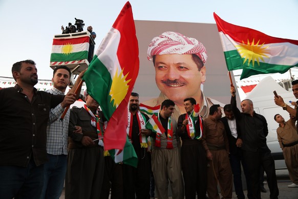 epa06203328 Kurdish men carry a portrait of President of the Iraqi Kurdistan Region Masoud Barzani as they take part in a march to support independence referendum in Erbil city, the Capital of the Kur ...