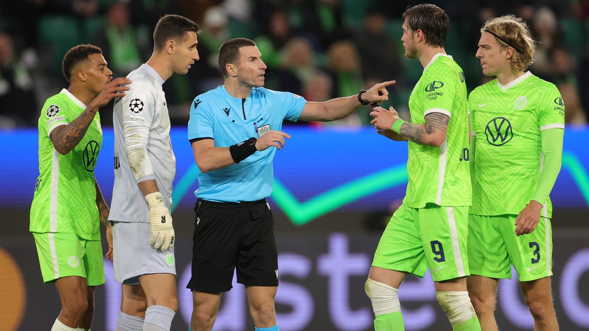 epa09496437 Referee Georgi Kabakov (C) talks to Wolfsburg's Wout Weghorst (R) during the UEFA Champions League group G soccer match between VfL Wolfsburg and Sevilla FC in Wolfsburg, Germany, 29  ...