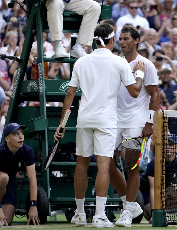 epa07713080 Roger Federer (L) of Switzerland celebrates winning against Rafael Nadal of Spain during their semi final match for the Wimbledon Championships at the All England Lawn Tennis Club, in Lond ...