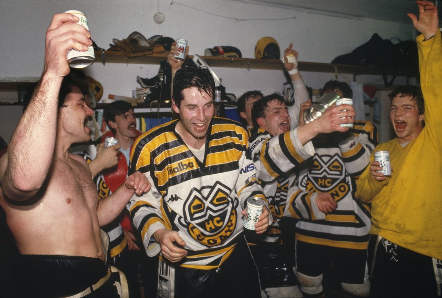 Die HC Lugano-Eishockeyspieler Beat Eggimann, Alfred Luethi, Andy Ton und Bernasconi feiern am 25. Maerz 1987 in der Garderobe im Stadion La Resega nach dem entscheidenden gewonnenen Playoff-Spiel geg ...