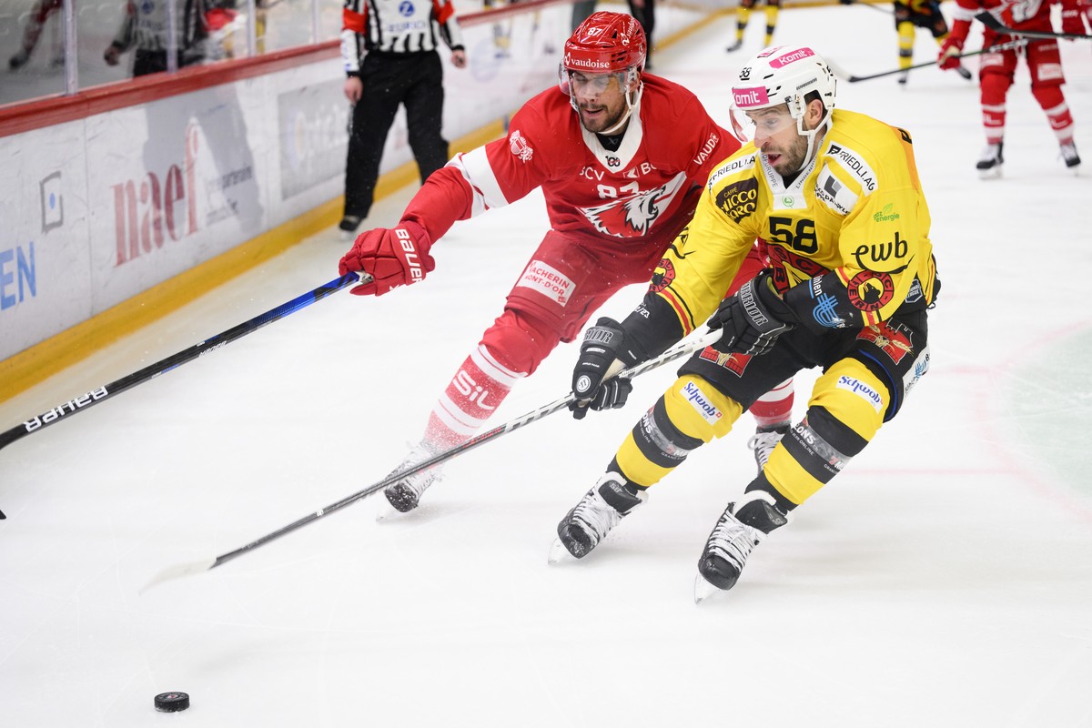 L'attaquant lausannois Marco Pedretti, gauche, lutte pour le puck avec le defenseur bernois Romain Loeffel, droite, lors du match du championnat suisse de hockey sur glace de National League entr ...