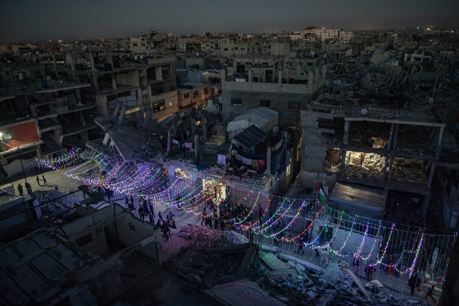 epaselect epa11931225 Palestinians hang decorations next to their destroyed homes in preparation for the holy month of Ramadan in Khan Yunis, southern Gaza Strip, 28 February 2025. The first day of Ra ...