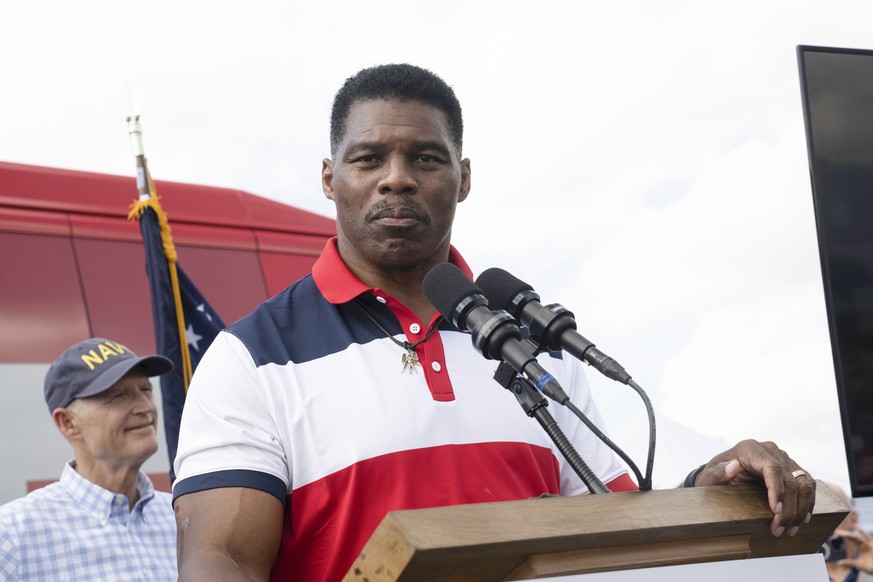 Sen. Rick Scott, R-Fla., left, listens as Georgia Republican Senate Candidate Herschel Walker speaks during a campaign stop on Tuesday, Oct. 11, 2022, in Carrollton, Ga. (AP Photo/Megan Varner)