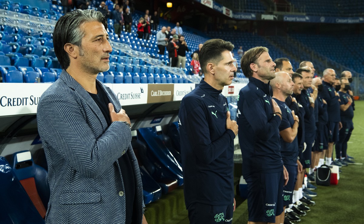 Switzerland's head coach Murat Yakin, left, sings the national anthem prior a soccer test match between Switzerland and Greece at the St. Jakob-Park stadium in Basel, Switzerland, on Wednesday, 1 ...