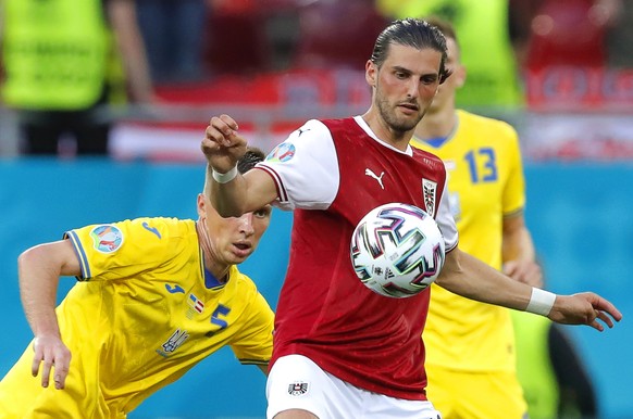 epa09291288 Serhiy Sydorchuk (L) of Ukraine in action against Florian Grillitsch (R) of Austria during the UEFA EURO 2020 group C preliminary round soccer match between Ukraine and Austria in Buchares ...