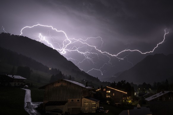 KEYPIX - Ein verzweigter Blitz durchschneidet den Gewitterhimmel ueber dem Tal in Richtung Gsteig, aufgenommen von Gstaad (BE), Schweiz, am Donnerstag, 16. Juli 2026. Waehrend eine Hitzewelle weiterhi ...