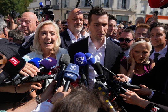 KEYPIX - Far-right leader Marine Le Pen and Far-right party National Rally president Jordan Bardella answer journalists as they arrive to visit a market in La Fleche, western France Wednesday, July. 8 ...