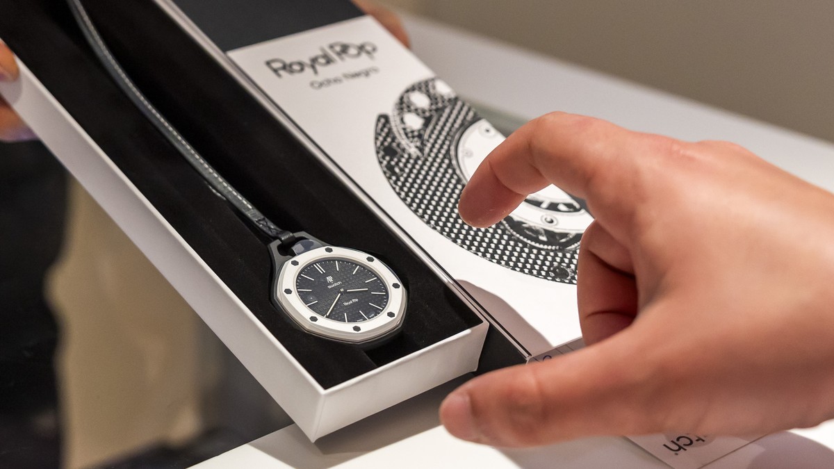 epa12962259 A saleswoman shows the new Royal Pop watch by Swatch and Audemars Piguet to a customer in Geneva, Switzerland, 16 May 2026. The collection of eight Royal Pop watches, combining Audemars Pi ...