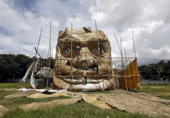 Artisans work on a giant model of mythological demon Mahisasura at a pandal, a temporary platform, during preparations for the upcoming Durga Puja festival in Kolkata, India, September 22, 2016. REUTE ...