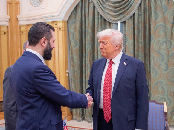 FILE - In this photo provided by the Saudi Royal Palace, Syria&#039;s interim President Ahmad al-Sharaa, left, shakes hands with U.S. President Donald Trump in Riyadh, Saudi Arabia, Wednesday, May 14, ...