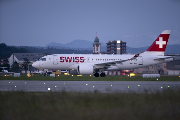 ZUM FLUGHAFEN ZUERICH IM DAEMMERLICHT UND BEI NACHT STELLEN WIR IHNEN FOLGENDES NEUES BILDMATERIAL ZUR VERFUEGUNG --- An Airbus Airbus A220-100 aircraft from Swiss International Air Lines (SWISS) at Z ...