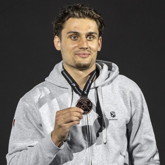 Switzerland&#039;s bronze medalist Ian Hauri on the podium of the Epee Men