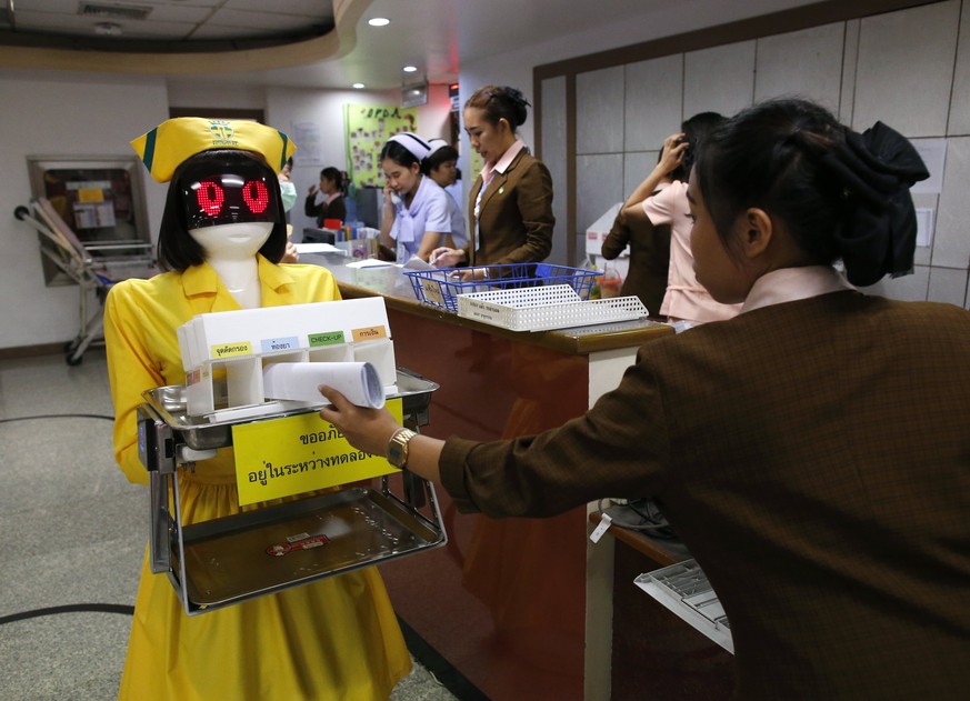 epa06426598 A Thai staff member put medical document to the Automated Guided Vehicles: AGV Robot dressed in nurse costume at Mongkutwattana General Hospital in Bangkok, Thailand, 09 January 2018. The  ...